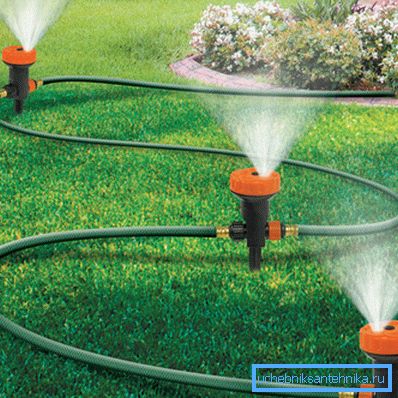 Bilden visar ett sprinklermunstycke som är sammankopplat med en trädgårdsslang.