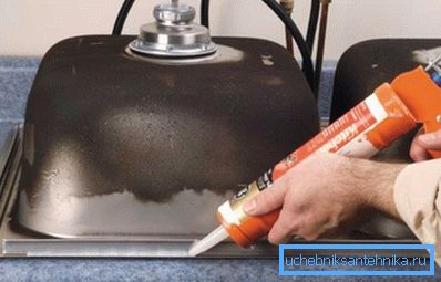 Applicera silikon på insidan av ett kökshandfat i rostfritt stål innan du installerar det i bänkskivan
