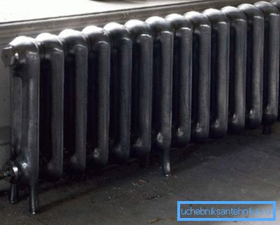 Stationär golv gjutjärn radiator installerad under fönstret